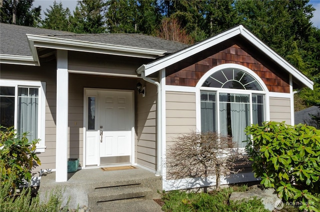 property entrance featuring a shingled roof