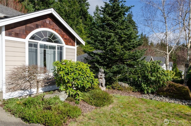 view of side of property featuring a shingled roof