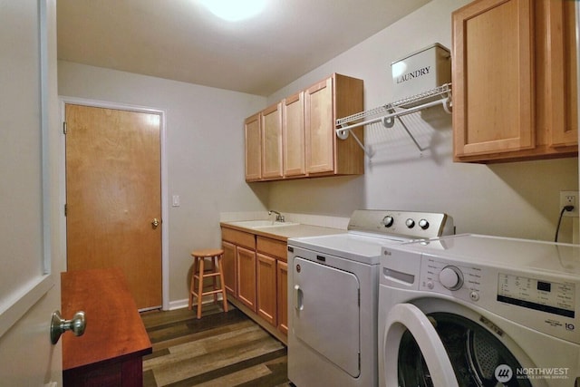 laundry room featuring cabinet space, baseboards, dark wood finished floors, separate washer and dryer, and a sink