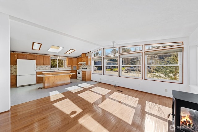 2308 Vista Ln, Anacortes, WA 98221 - kitchen featuring white appliances, a kitchen island, light countertops, light wood-type flooring, and tasteful backsplash