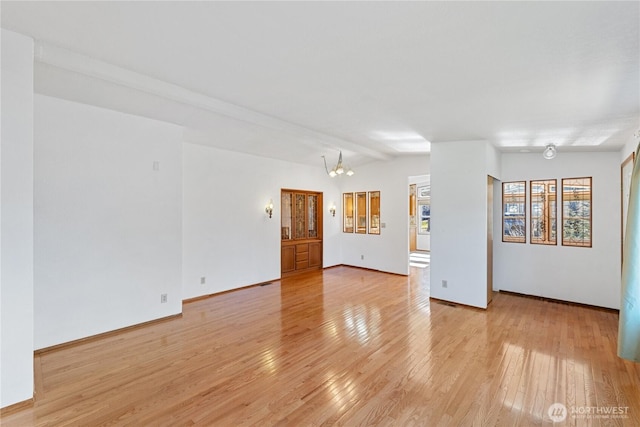 2308 Vista Ln, Anacortes, WA 98221 - empty room with light wood-type flooring, baseboards, a chandelier, and lofted ceiling