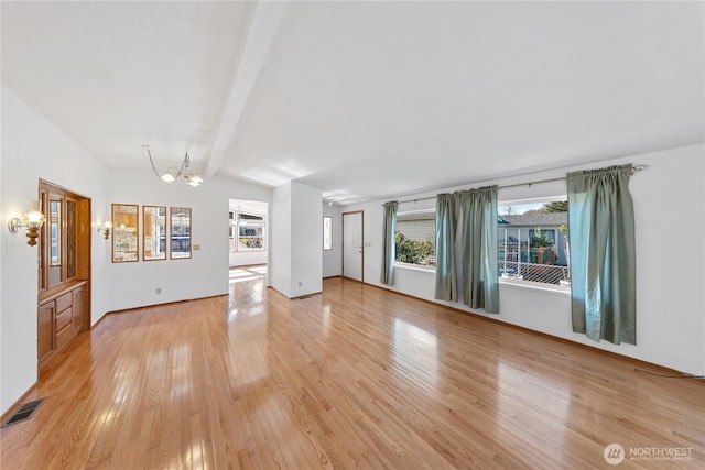 2308 Vista Ln, Anacortes, WA 98221 - unfurnished living room with vaulted ceiling with beams, light wood finished floors, visible vents, an inviting chandelier, and baseboards
