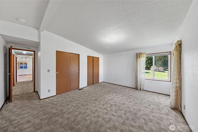 2308 Vista Ln, Anacortes, WA 98221 - unfurnished bedroom with multiple closets, carpet, vaulted ceiling with beams, and a textured ceiling