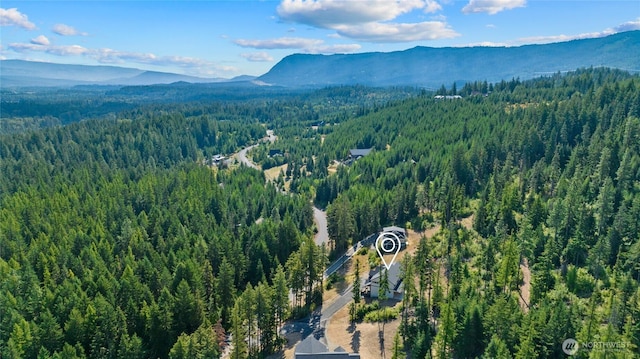 birds eye view of property featuring a forest view and a mountain view