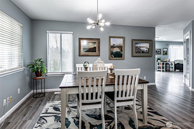 dining space featuring dark wood-style floors, a chandelier, and baseboards