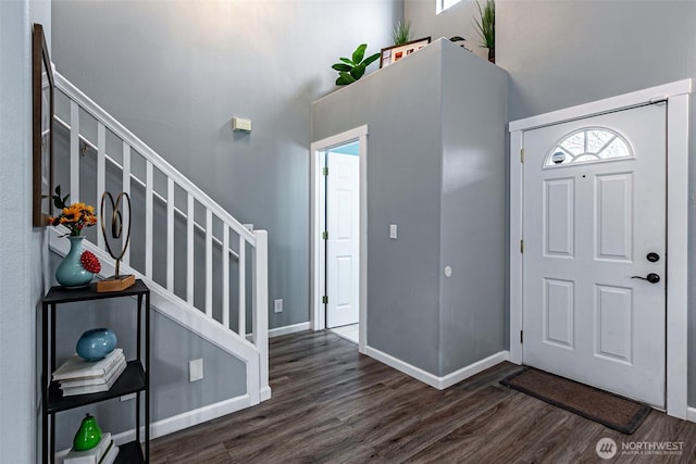 foyer featuring stairway, wood finished floors, and baseboards