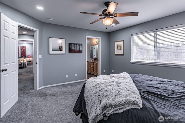 bedroom with ensuite bath, carpet flooring, a ceiling fan, and baseboards