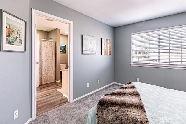 bedroom featuring carpet, visible vents, ensuite bath, and baseboards