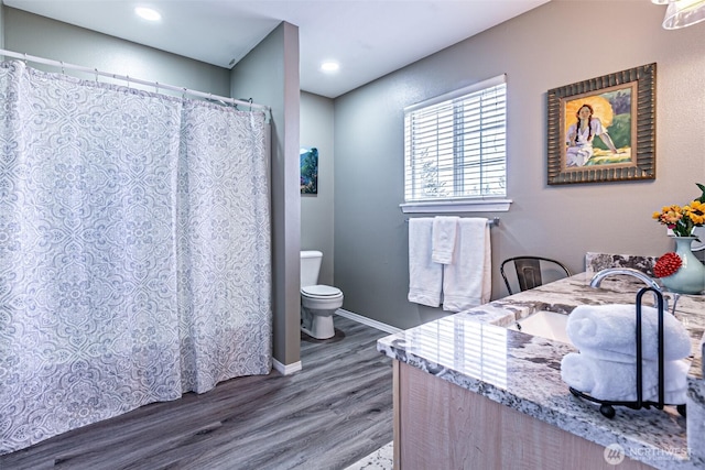 bathroom with vanity, wood finished floors, toilet, and baseboards