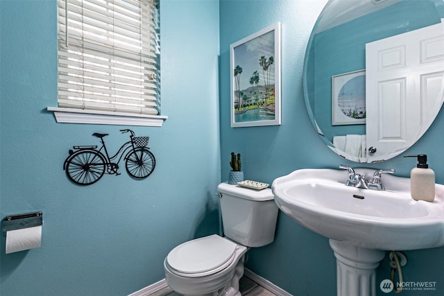 bathroom featuring toilet and baseboards