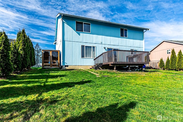 rear view of house with a lawn and a deck