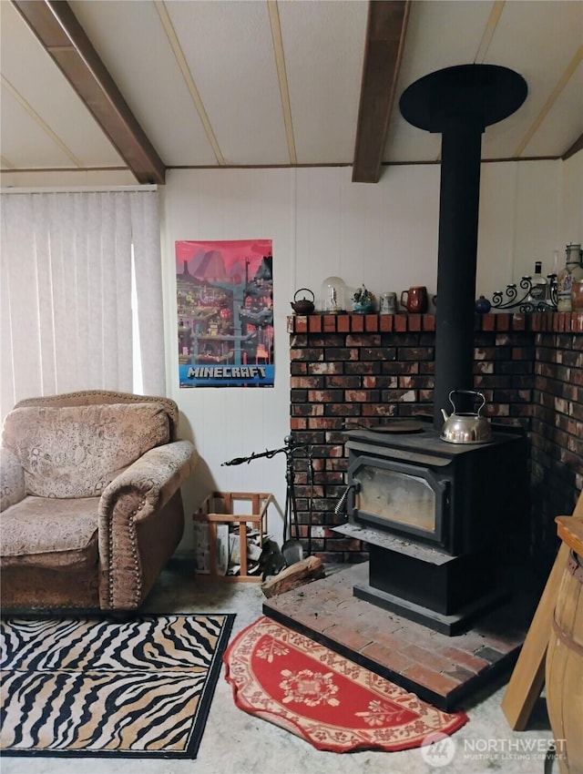 living area featuring a wood stove and beamed ceiling