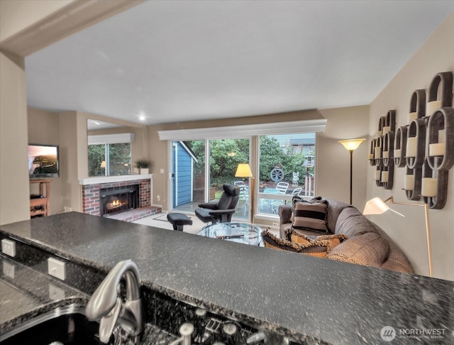 kitchen with a brick fireplace, open floor plan, and dark countertops