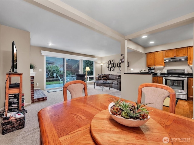 dining area with recessed lighting, beam ceiling, and light carpet