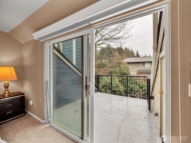 entryway with baseboards, vaulted ceiling, and carpet flooring