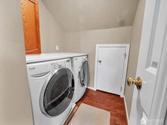 laundry area with cabinet space, baseboards, washer and dryer, and wood finished floors