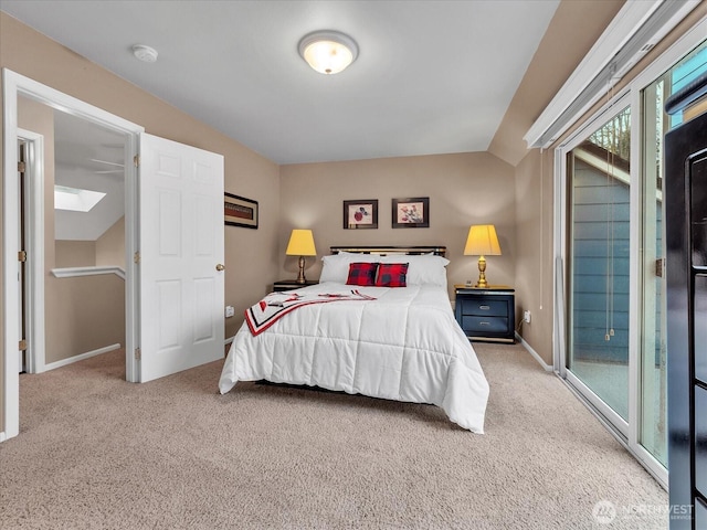 bedroom featuring access to outside, vaulted ceiling with skylight, carpet flooring, and baseboards