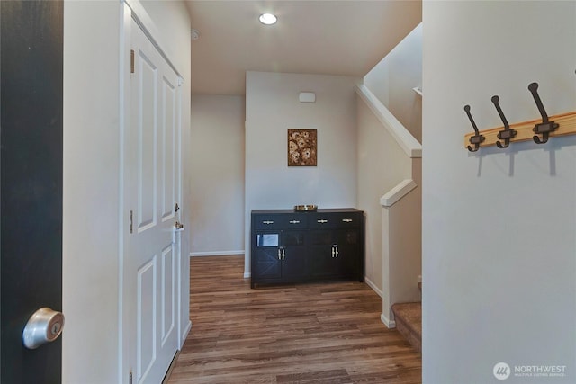 hall featuring stairs, wood finished floors, and baseboards