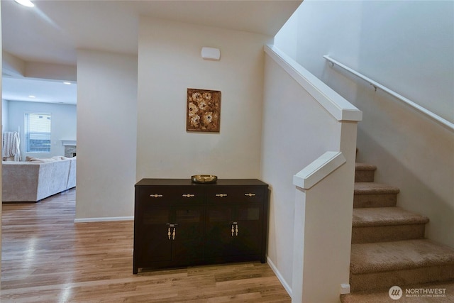 stairway with wood finished floors and baseboards