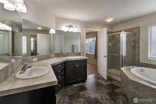 full bathroom featuring double vanity, a sink, a shower stall, plenty of natural light, and a bath