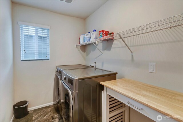 washroom with baseboards, laundry area, and washer and dryer