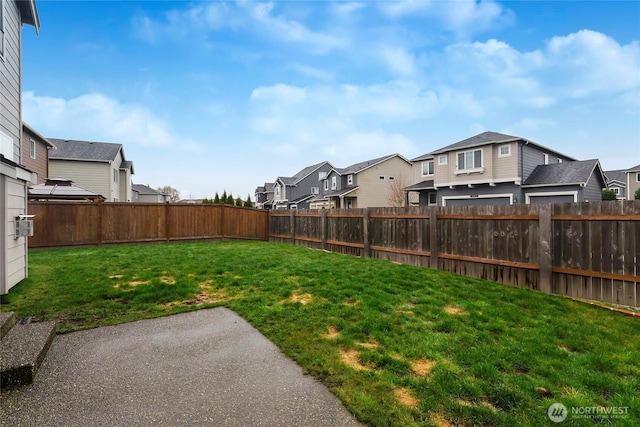 view of yard featuring a fenced backyard and a residential view