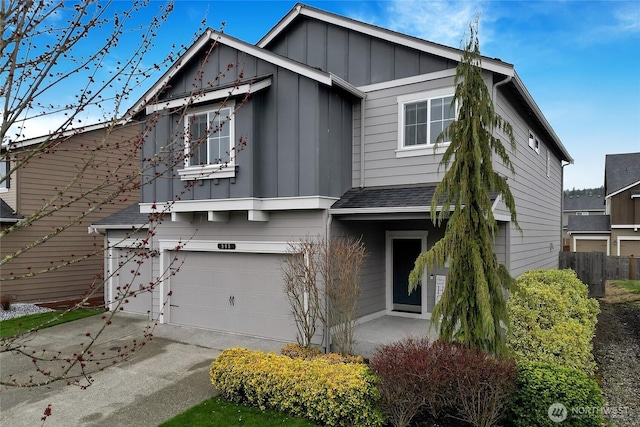 view of front of home with a shingled roof, board and batten siding, fence, a garage, and driveway