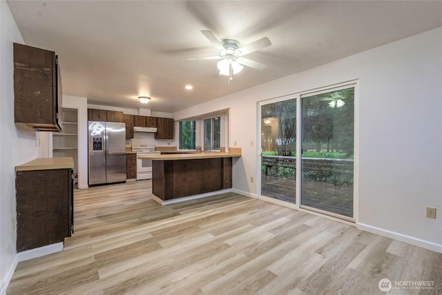 kitchen with electric stove, light countertops, light wood-type flooring, a peninsula, and stainless steel fridge with ice dispenser