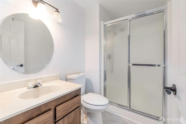 bathroom with tile patterned flooring, a shower stall, toilet, and vanity