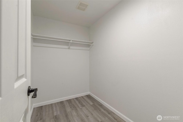 walk in closet with wood finished floors and visible vents