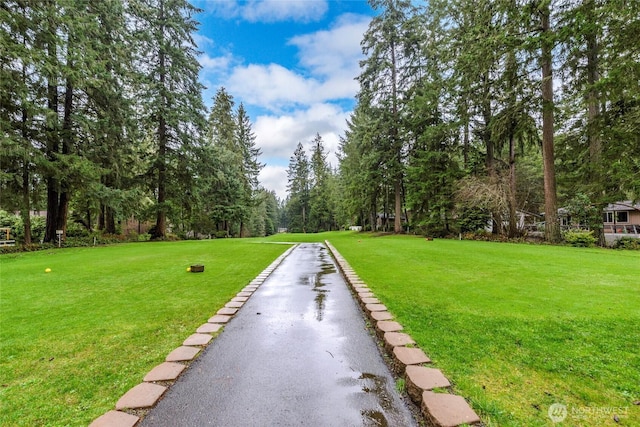 surrounding community with aphalt driveway and a lawn