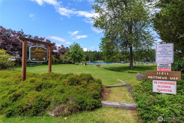 view of property's community with a water view and a yard