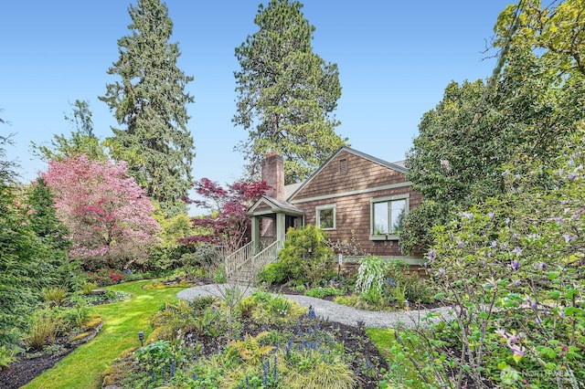 view of front of home with a chimney and a front yard