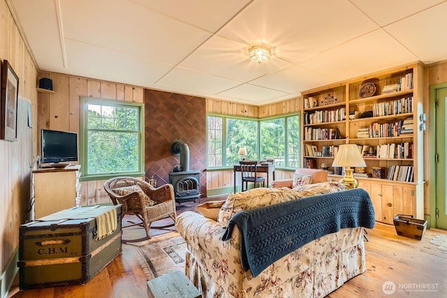 sitting room with a wood stove, plenty of natural light, and hardwood / wood-style flooring