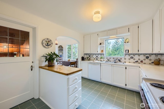 kitchen featuring arched walkways, stove, a sink, white cabinets, and dishwasher