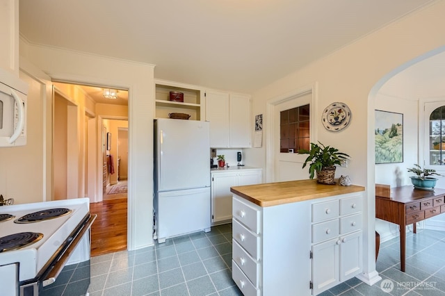 kitchen with white appliances, arched walkways, butcher block counters, white cabinetry, and open shelves