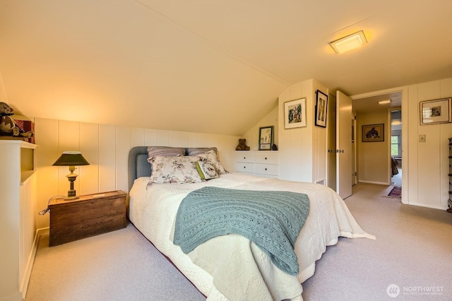 carpeted bedroom with lofted ceiling