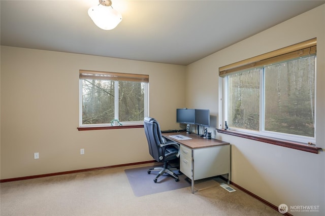 carpeted office space featuring visible vents and baseboards