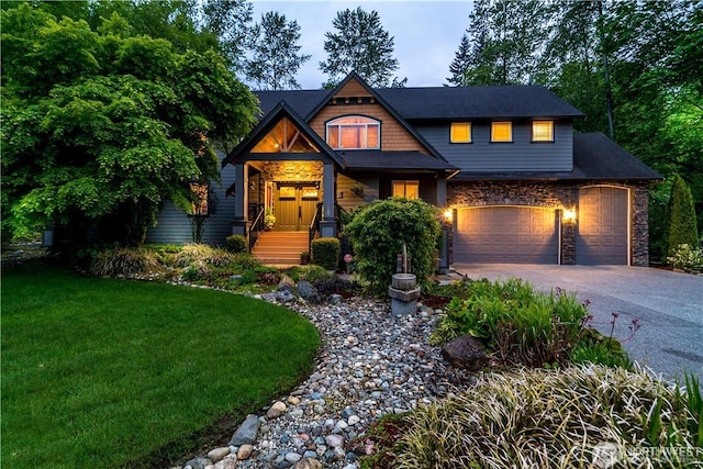 craftsman inspired home with an attached garage, concrete driveway, stone siding, and a front yard