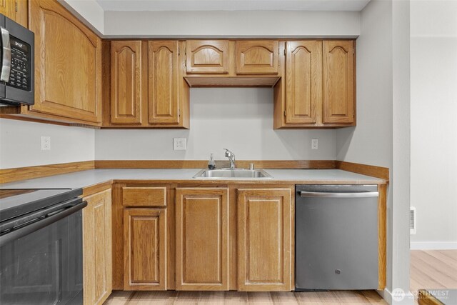 kitchen with a sink, light countertops, brown cabinetry, black electric range, and stainless steel dishwasher