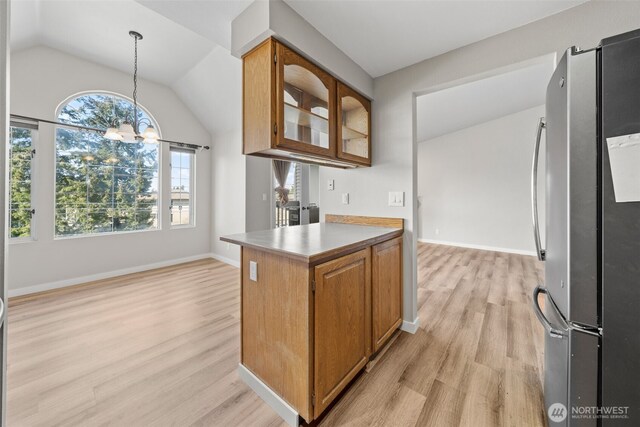 kitchen with light wood-style floors, freestanding refrigerator, vaulted ceiling, and a notable chandelier