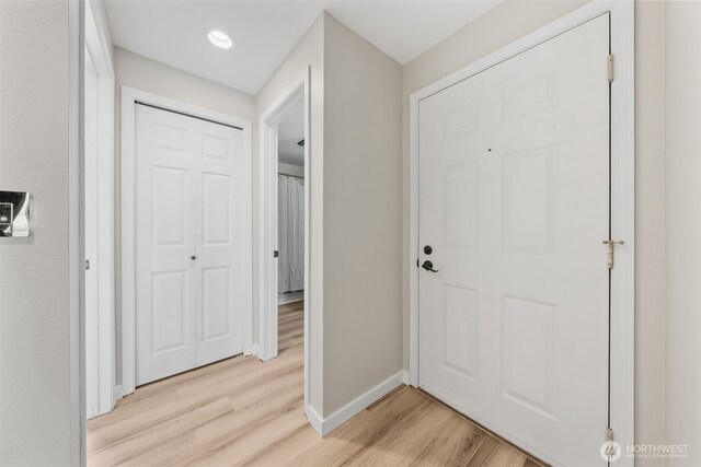 hallway featuring baseboards and light wood-type flooring