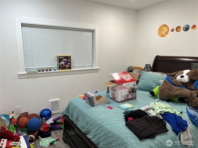 bedroom featuring visible vents and wood finished floors