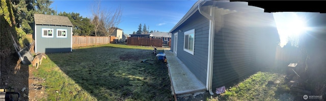 view of yard with a fenced backyard, an outdoor structure, and a shed