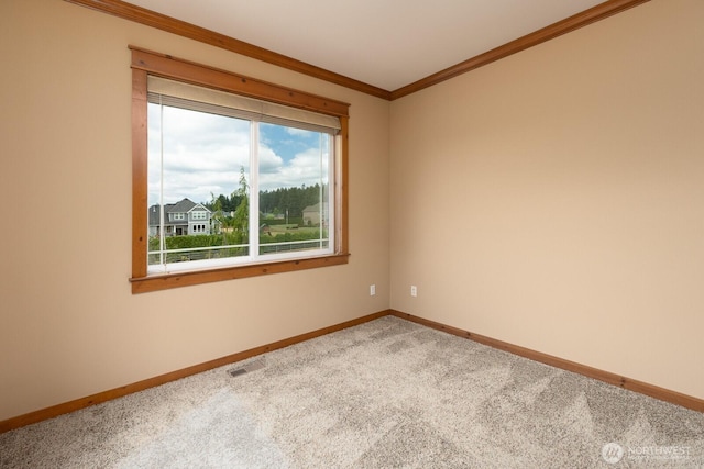 carpeted spare room featuring baseboards, visible vents, and crown molding