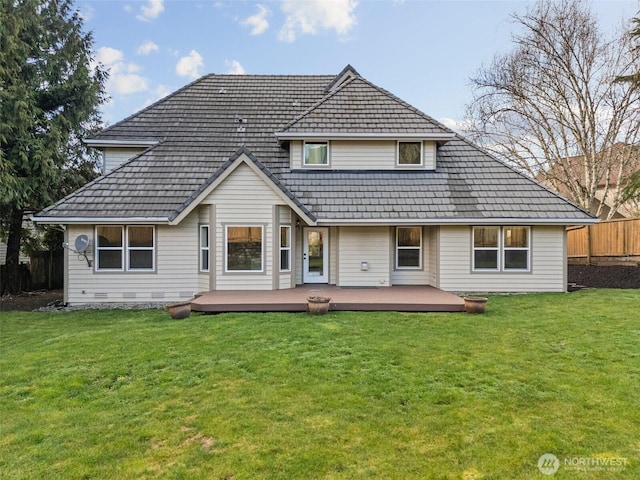 back of property featuring a yard, a wooden deck, and fence