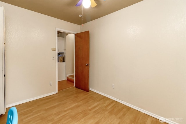 unfurnished bedroom featuring light wood finished floors, baseboards, and a ceiling fan