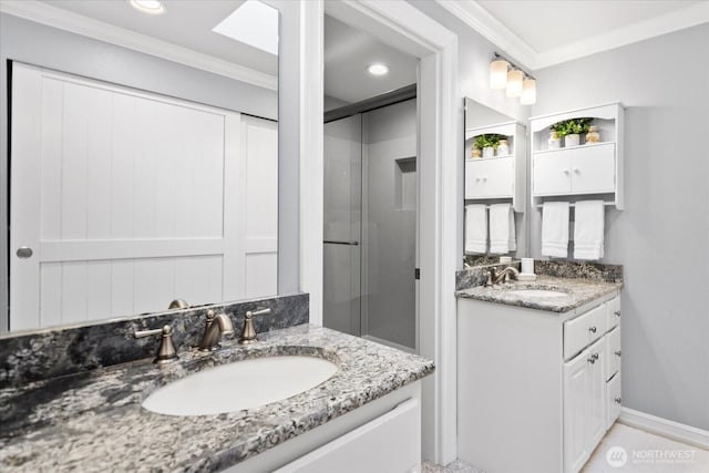 full bathroom with a stall shower, two vanities, a sink, and crown molding