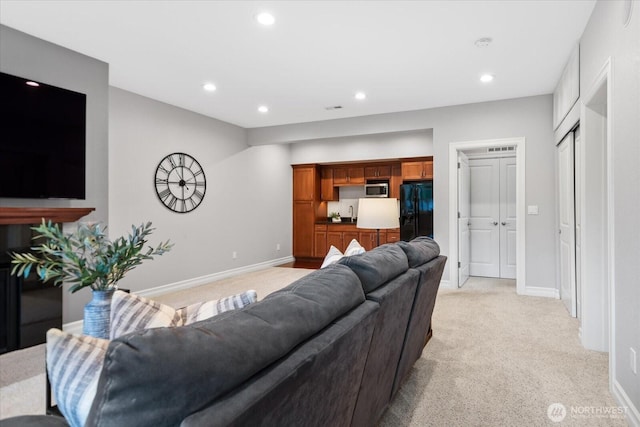 living area with recessed lighting, light carpet, and baseboards