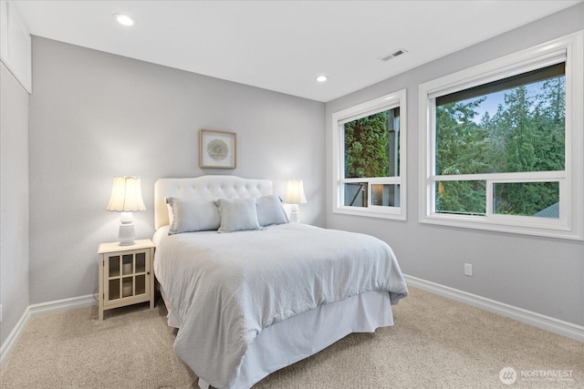 bedroom with light colored carpet, visible vents, and baseboards